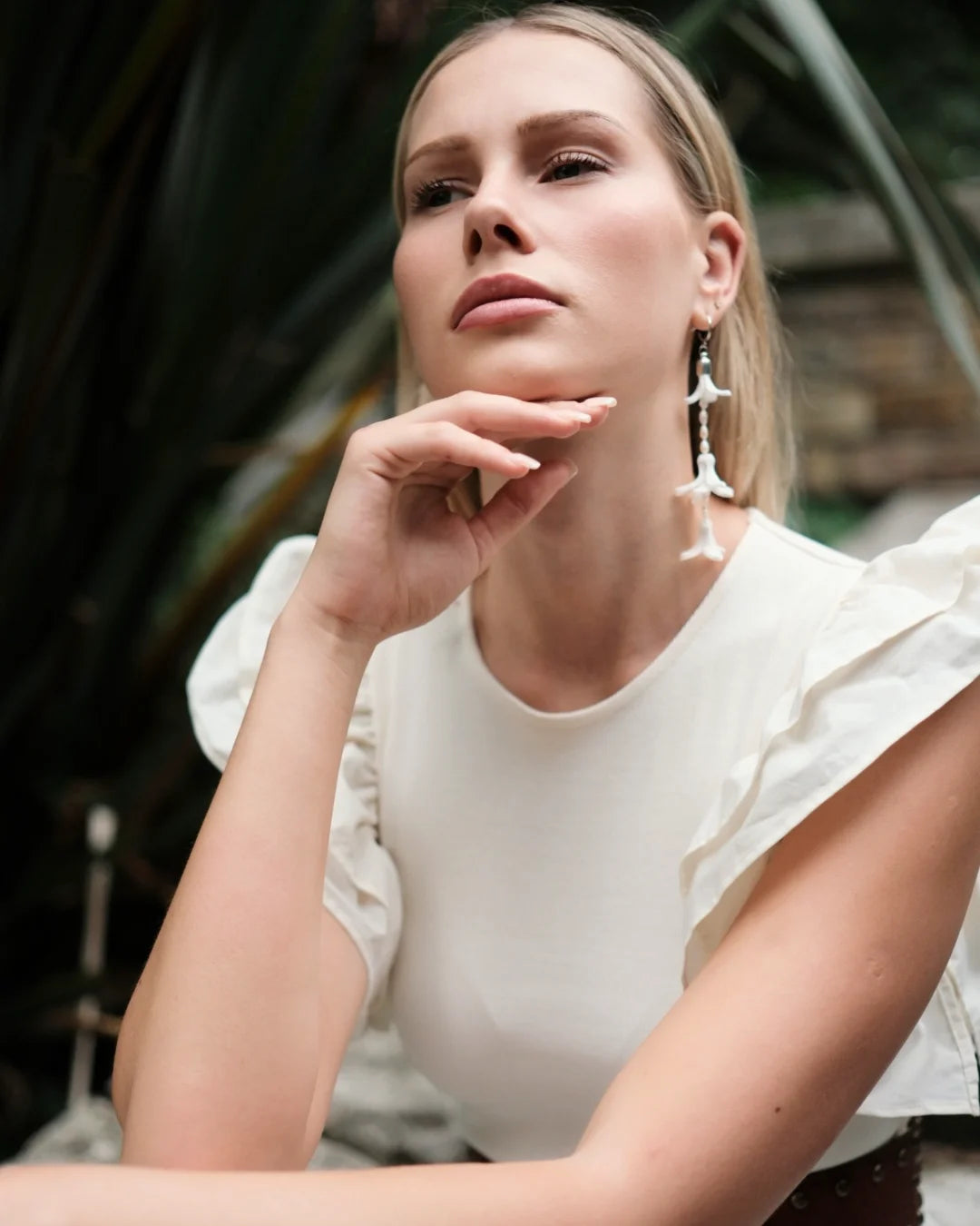 Model wearing long white hyacinth floral wedding earrings by Deco Flowers