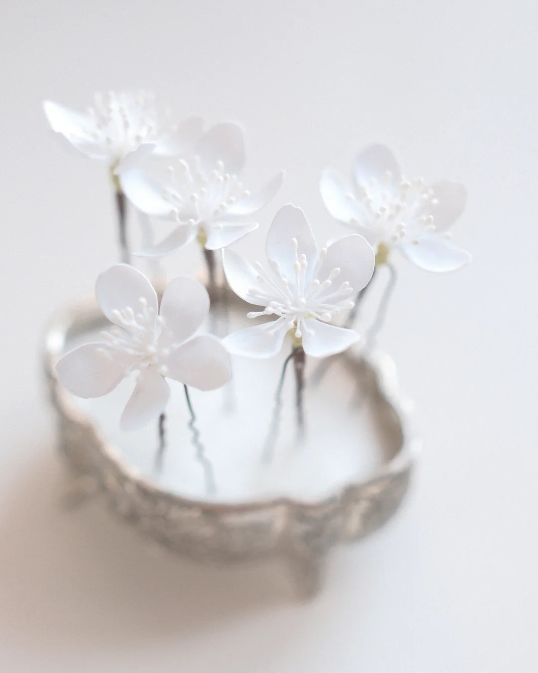 White flower hair pins scattered through a bridal hairstyle