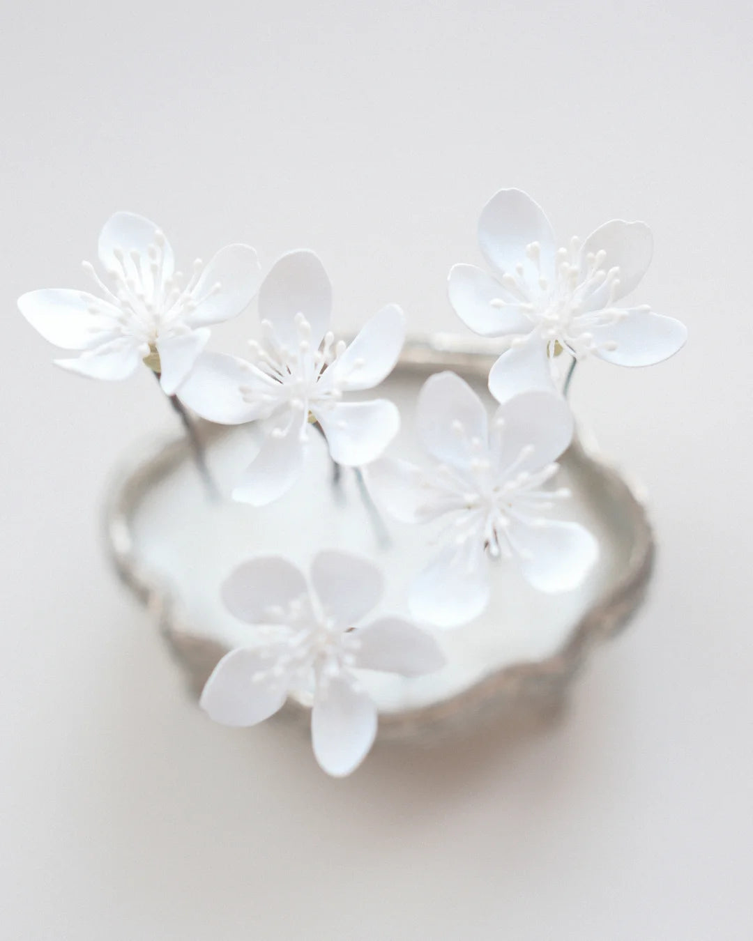 Hand-sculpted white cherry blossom hair pin close-up