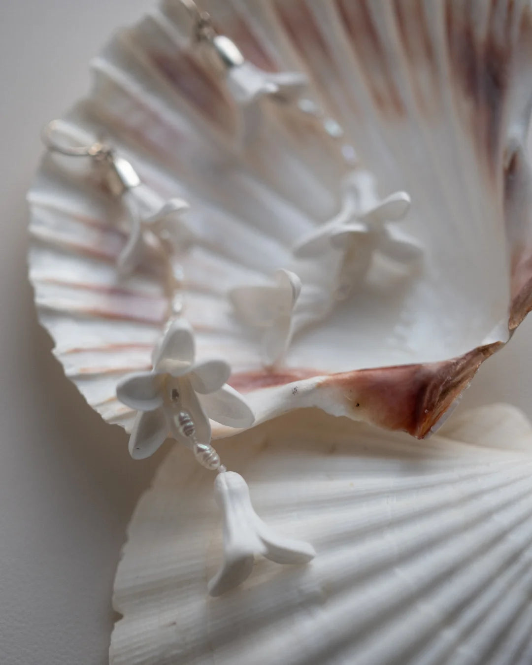 Detailed shot of artisanal white flower wedding earrings.
