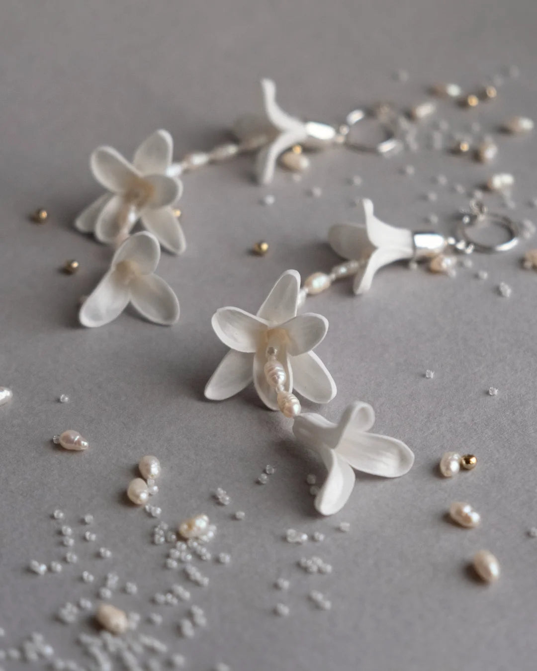 Deco Flowers ‘Hyacinth’ white floral statement bridal earrings with vintage pearls and sterling silver, displayed vertically to show their elegant 11cm drop length.