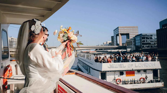 Real bride wearing a bespoke large white floral hair accessory by Decoflowers during a London boat wedding on the River Thames.